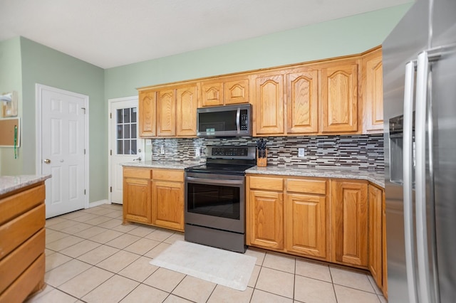 112 Lewellin Pl, Lufkin, TX 75904 - kitchen featuring stainless steel appliances, tasteful backsplash, light tile patterned flooring, and light stone counters