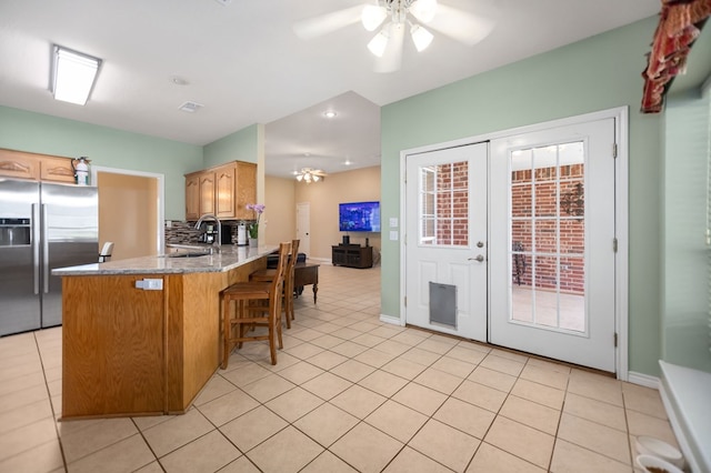 112 Lewellin Pl, Lufkin, TX 75904 - kitchen featuring stainless steel fridge with ice dispenser, a sink, a peninsula, ceiling fan, and light tile patterned flooring