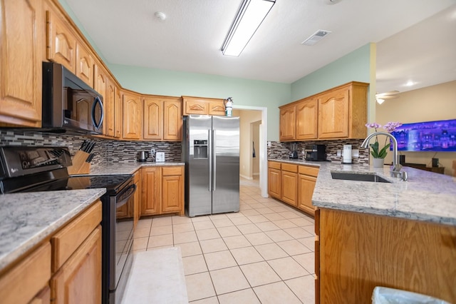 112 Lewellin Pl, Lufkin, TX 75904 - kitchen featuring stainless steel fridge with ice dispenser, black range with electric stovetop, a sink, decorative backsplash, and light tile patterned flooring