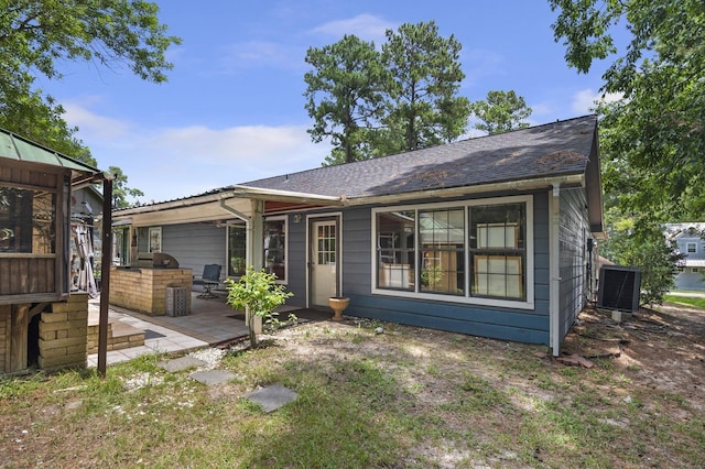 rear view of property with central air condition unit and exterior kitchen