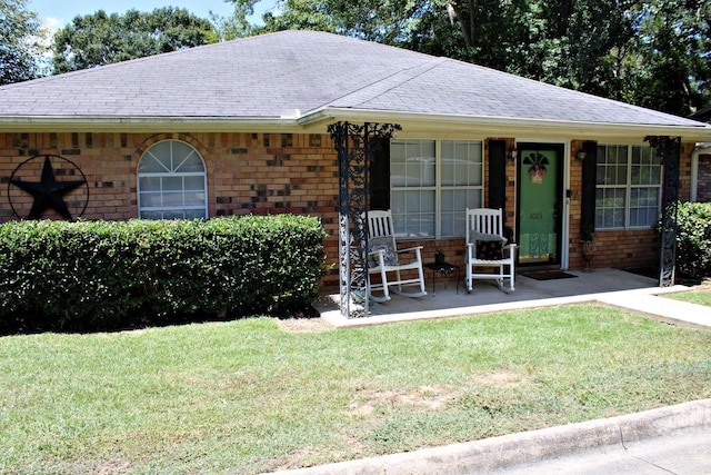 ranch-style home with a front lawn and covered porch