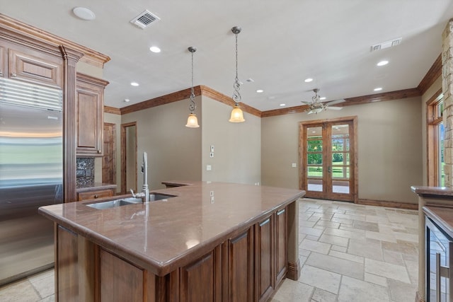 4207 S Chestnut St, Lufkin, TX 75901 - kitchen with built in fridge, a sink, stone tile flooring, ornamental molding, and an island with sink