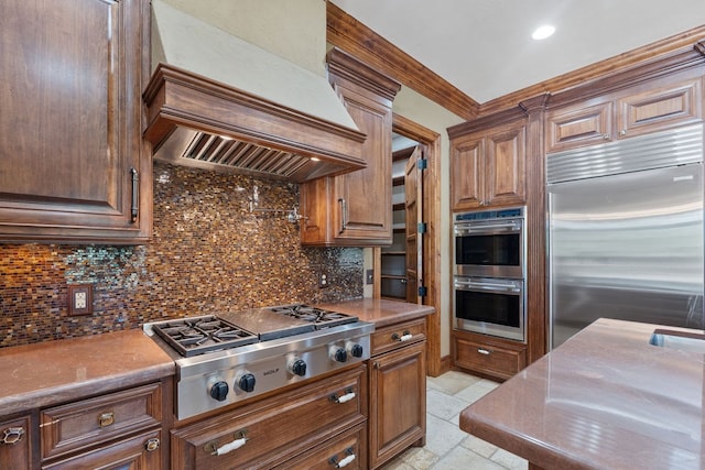 4207 S Chestnut St, Lufkin, TX 75901 - kitchen with stainless steel appliances, wall chimney exhaust hood, backsplash, stone tile flooring, and recessed lighting