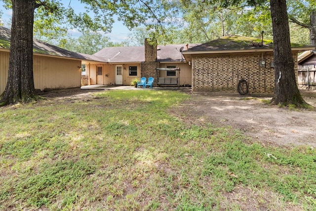 rear view of house with a patio and a lawn