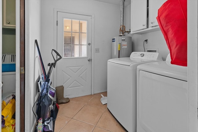 clothes washing area featuring cabinets, light tile patterned floors, separate washer and dryer, and water heater