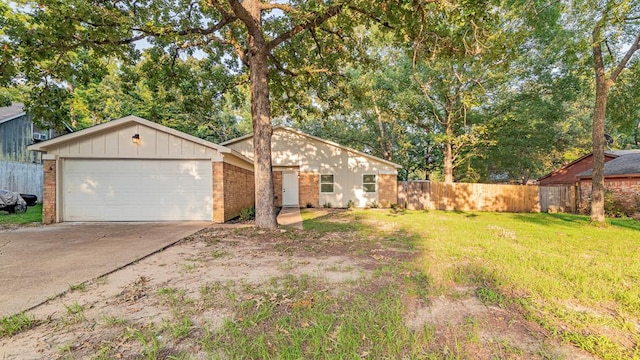 view of front facade with a garage, concrete driveway, fence, a front lawn, and brick siding