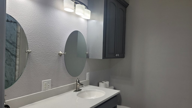 138 Breezeway Dr, Brookeland, TX 75931 - bathroom featuring toilet, vanity, and a textured wall
