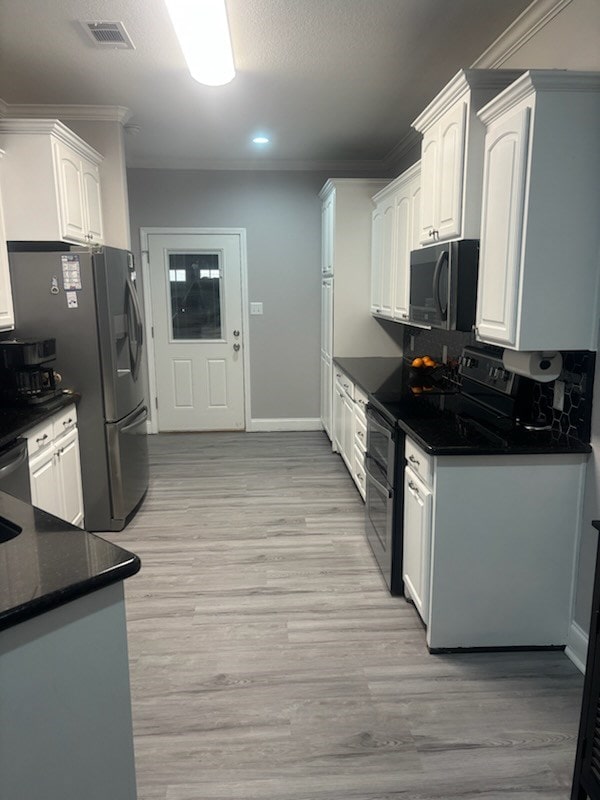 138 Breezeway Dr, Brookeland, TX 75931 - kitchen with stainless steel refrigerator with ice dispenser, visible vents, light wood finished floors, range with two ovens, and white cabinets
