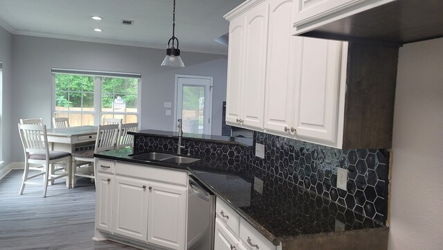 138 Breezeway Dr, Brookeland, TX 75931 - kitchen with stainless steel dishwasher, a sink, a peninsula, crown molding, and decorative backsplash