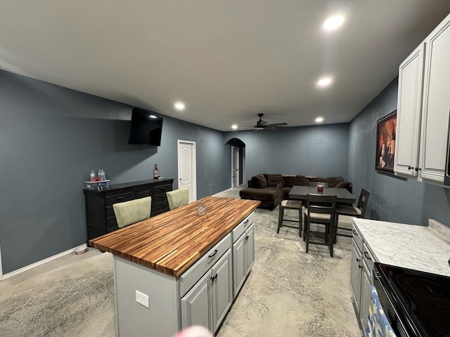 0103 Old Fm 705, Broaddus, TX 75979 - kitchen with butcher block counters, a ceiling fan, recessed lighting, a kitchen island, and electric range
