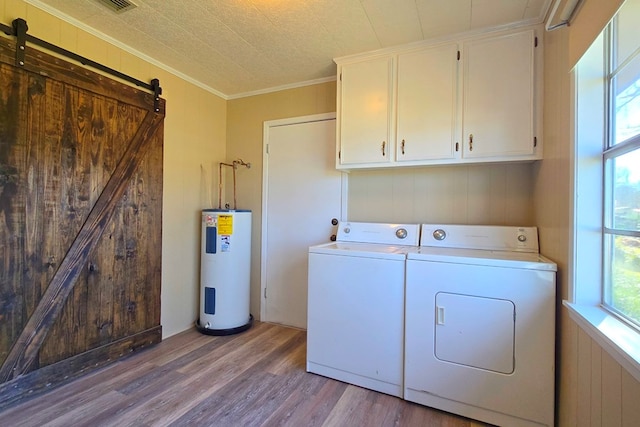 laundry room featuring a barn door, electric water heater, separate washer and dryer, wood finished floors, and cabinet space