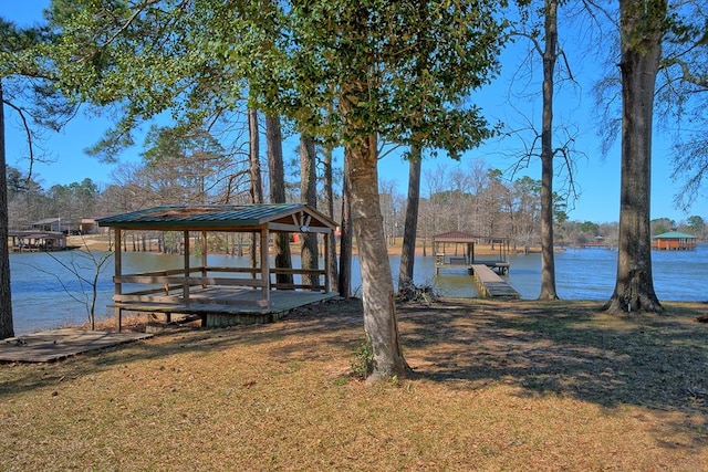 view of dock with a water view, a yard, and a gazebo