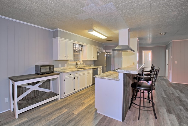 kitchen with dark wood-style floors, a breakfast bar, white cabinetry, a sink, and exhaust hood