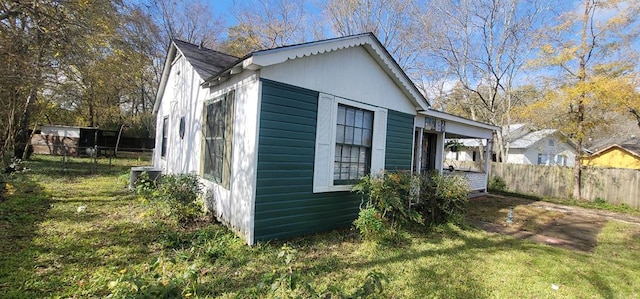 view of home's exterior featuring cooling unit and a lawn