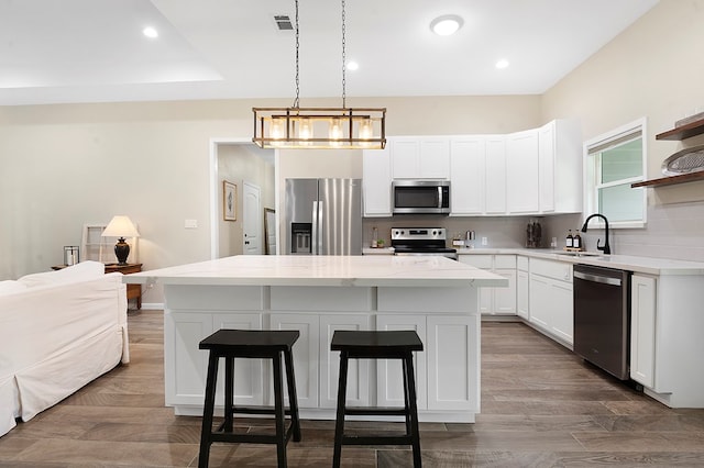 155 Sweetbriar Ct, Brookeland, TX 75931 - kitchen featuring appliances with stainless steel finishes, open shelves, a center island, a breakfast bar, and decorative backsplash