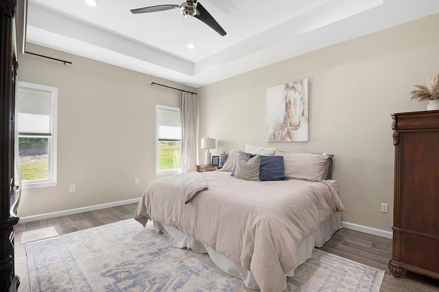 155 Sweetbriar Ct, Brookeland, TX 75931 - bedroom with multiple windows, wood finished floors, recessed lighting, a tray ceiling, and a ceiling fan