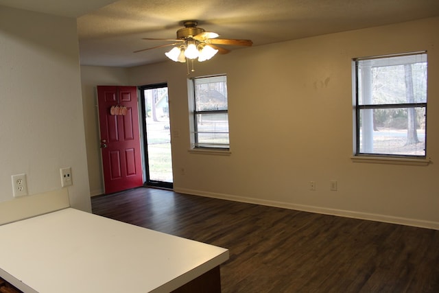 foyer with a ceiling fan, a textured ceiling, baseboards, and dark wood-type flooring