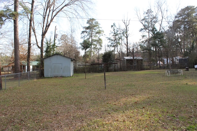 view of yard with an outdoor structure, fence, and a storage unit