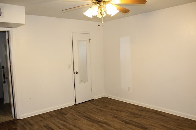 empty room featuring dark wood-style floors, baseboards, and a ceiling fan