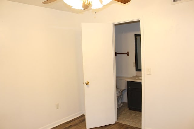 unfurnished bedroom with ceiling fan, visible vents, baseboards, and dark wood-type flooring