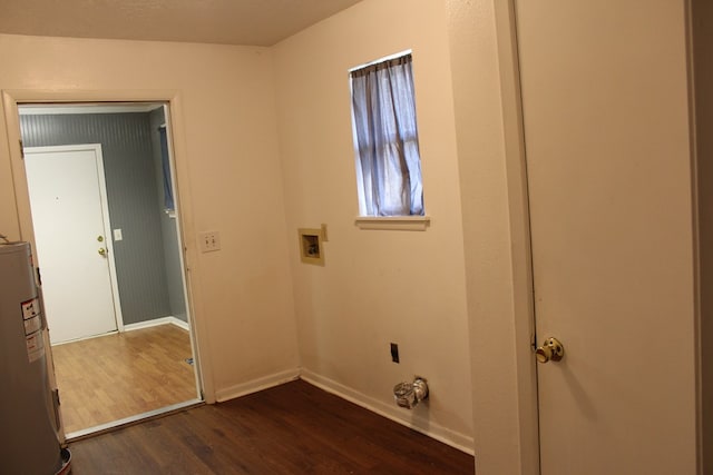 washroom featuring dark wood-type flooring, laundry area, electric water heater, and baseboards