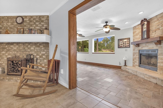 living room with a stone fireplace, ceiling fan, and ornamental molding