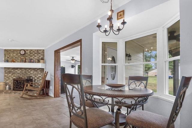 dining room featuring crown molding, a fireplace, light tile patterned floors, and ceiling fan with notable chandelier