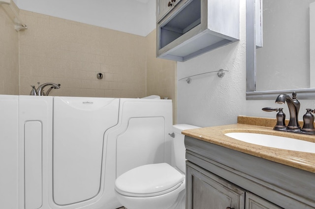 bathroom featuring a bathtub, toilet, and vanity