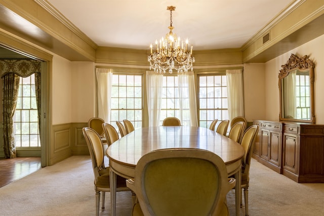 carpeted dining space with crown molding and a notable chandelier