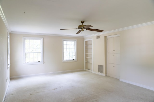 unfurnished room with light carpet, ornamental molding, ceiling fan, and a healthy amount of sunlight