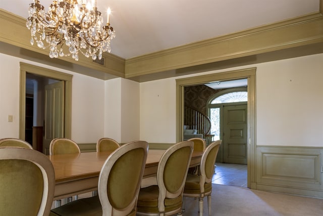 dining area with a chandelier, light carpet, and ornamental molding