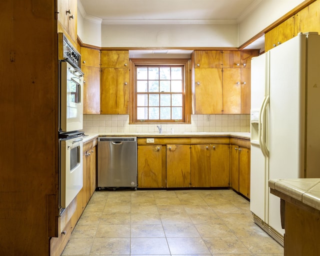 kitchen featuring tile counters, white appliances, crown molding, and tasteful backsplash