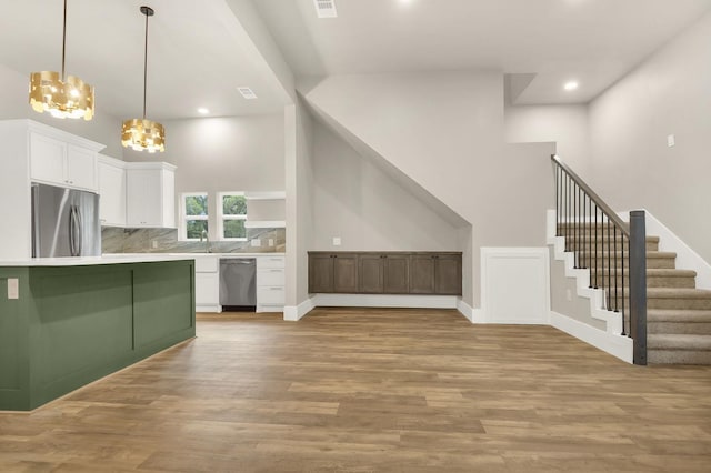 kitchen featuring an inviting chandelier, white cabinets, decorative light fixtures, light hardwood / wood-style floors, and stainless steel appliances