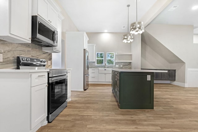 kitchen featuring appliances with stainless steel finishes, a kitchen island, pendant lighting, light hardwood / wood-style flooring, and white cabinetry