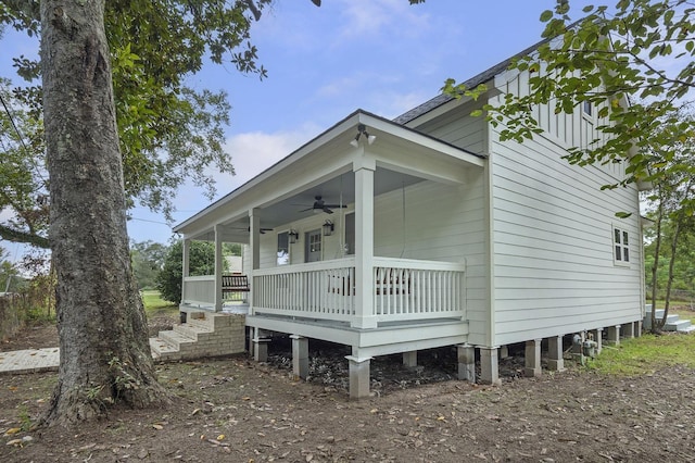 view of side of home with ceiling fan and covered porch