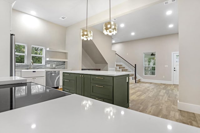 kitchen featuring decorative light fixtures, light hardwood / wood-style flooring, dishwasher, a chandelier, and green cabinets