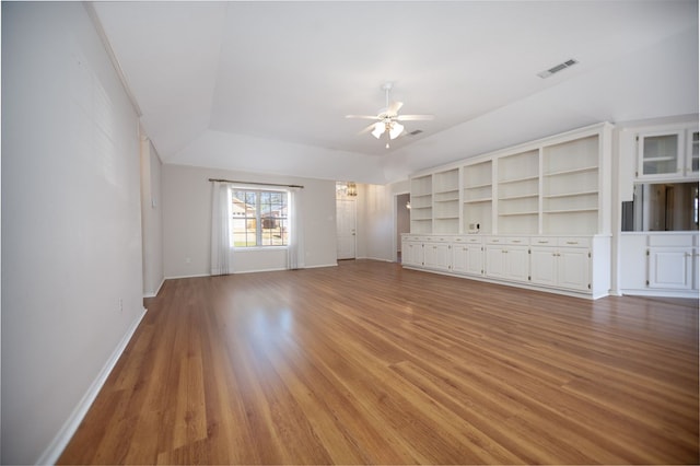 3712 Ashbury Ln, Nacogdoches, TX 75965 - unfurnished living room featuring a ceiling fan, light wood-style floors, baseboards, and a raised ceiling