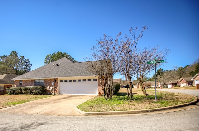 3712 Ashbury Ln, Nacogdoches, TX 75965 - ranch-style home featuring an attached garage, concrete driveway, brick siding, and roof with shingles