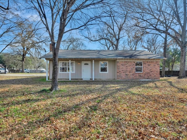 single story home featuring brick siding, board and batten siding, a chimney, and a front lawn