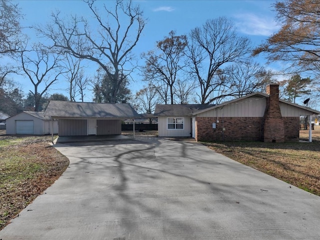 view of front of home with a chimney, a carport, board and batten siding, and driveway