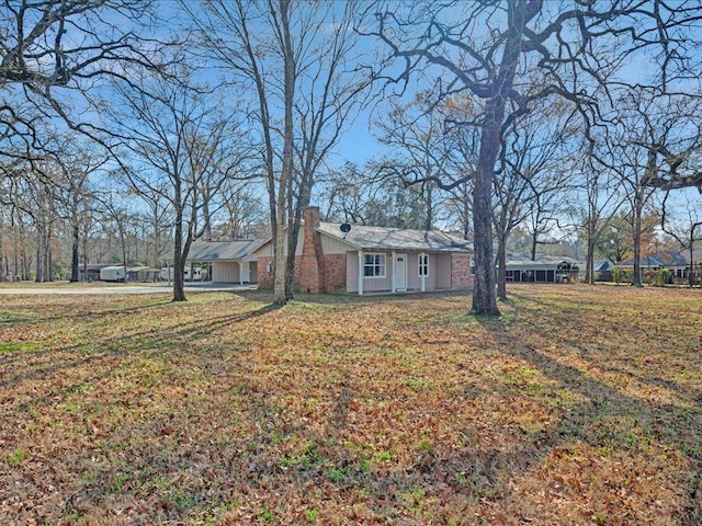 view of front of home featuring a chimney and a front lawn