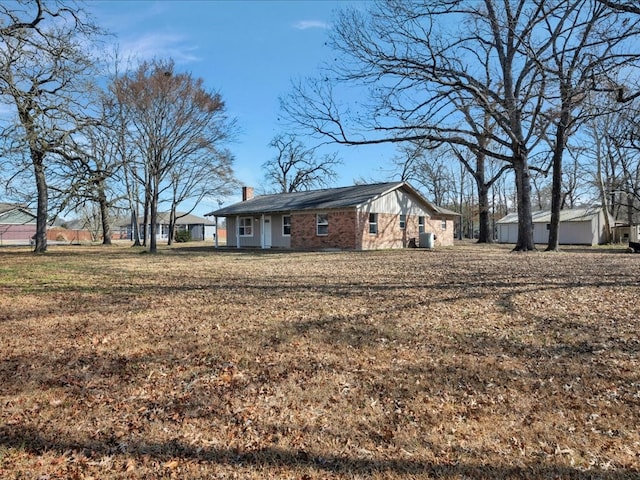 exterior space with a chimney and a front lawn