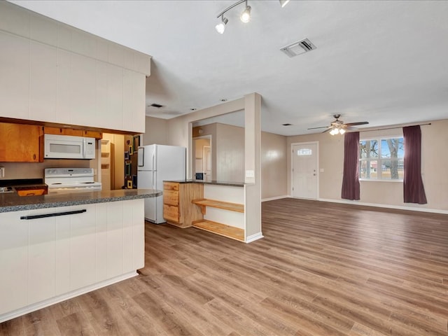 kitchen featuring white appliances, visible vents, light wood finished floors, ceiling fan, and dark countertops