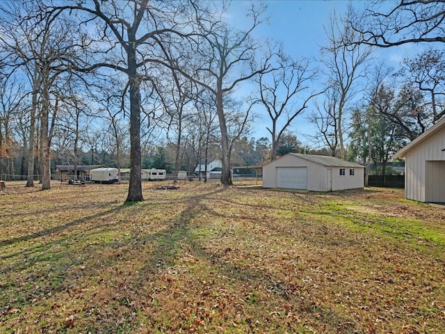 view of yard featuring an outdoor structure, fence, and a garage