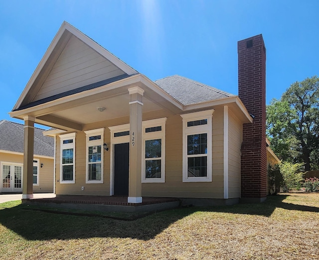 rear view of property with a porch and a lawn