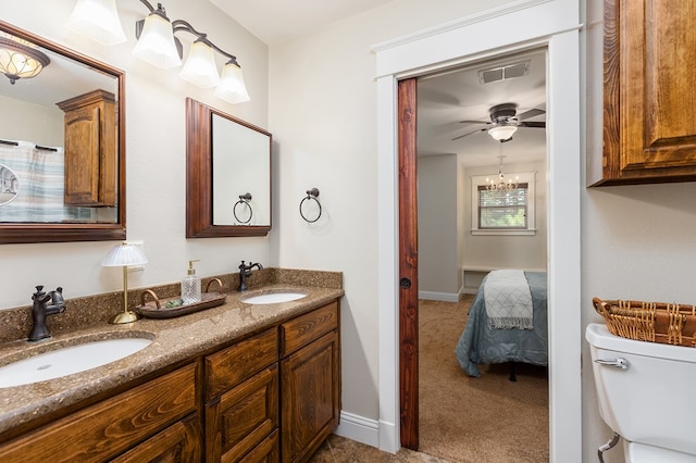 bathroom featuring ceiling fan with notable chandelier, vanity, and toilet