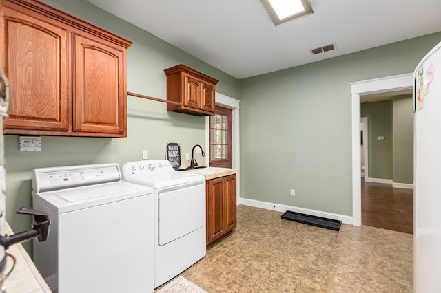 laundry area with sink, cabinets, and washer and dryer