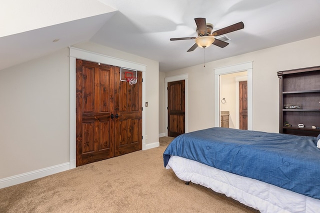 carpeted bedroom featuring connected bathroom, vaulted ceiling, and ceiling fan