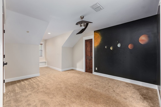 bonus room with light colored carpet and vaulted ceiling