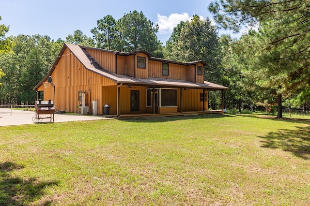 rear view of house with a yard, cooling unit, and a patio